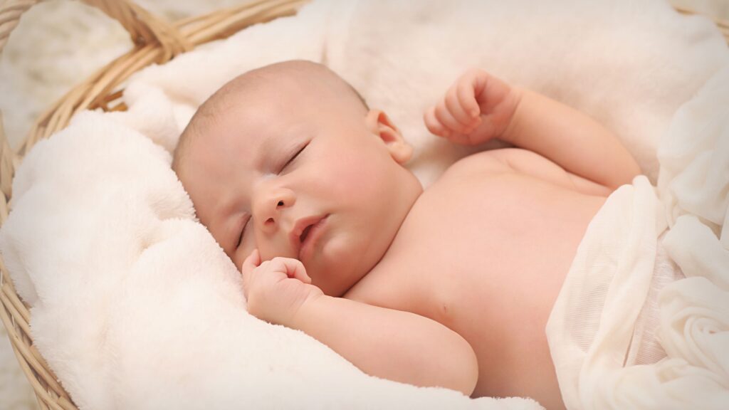 newborn sleeeping in a bassinet